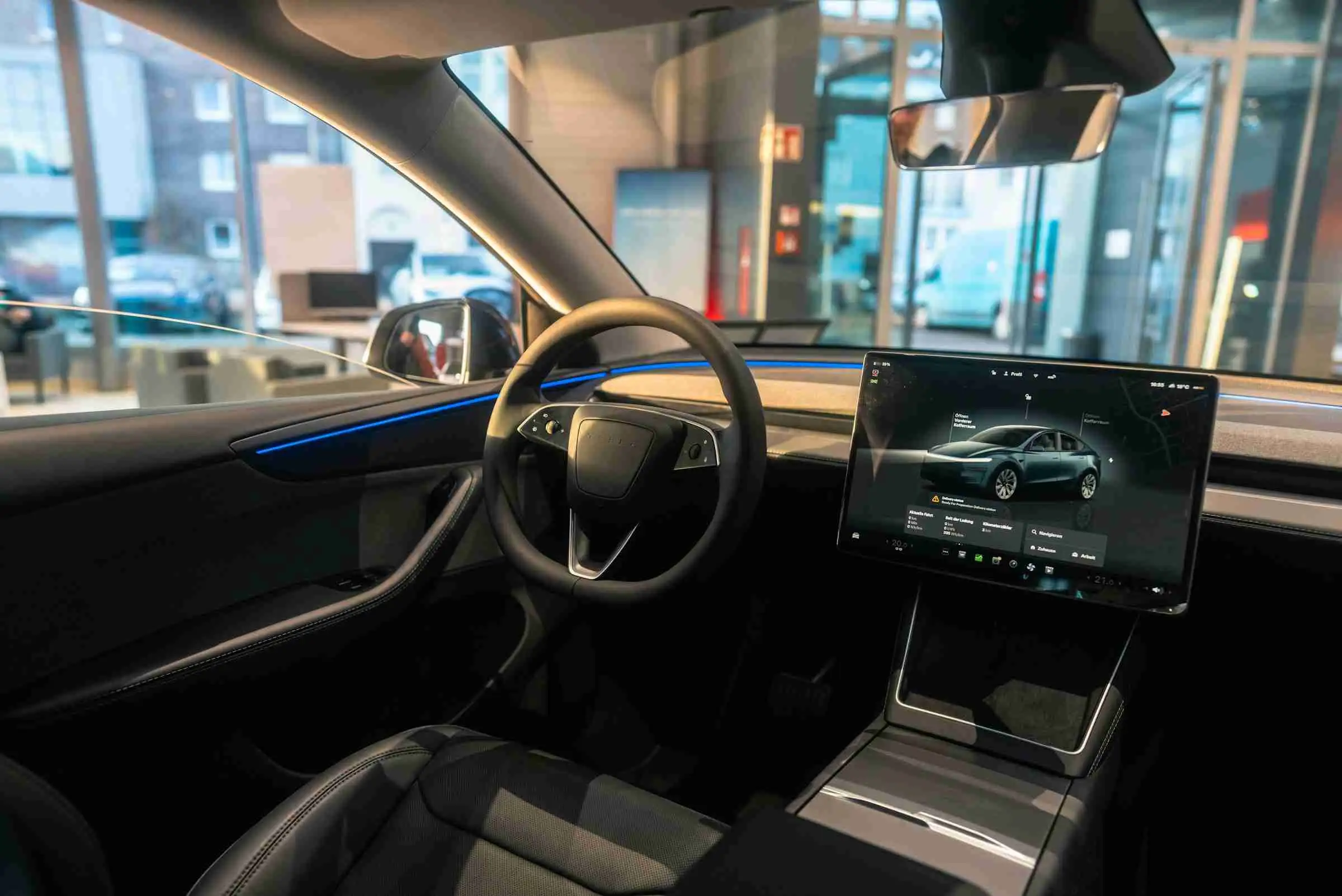 Interior of a Tesla Model Y taxi with panoramic glass roof and ambient lighting